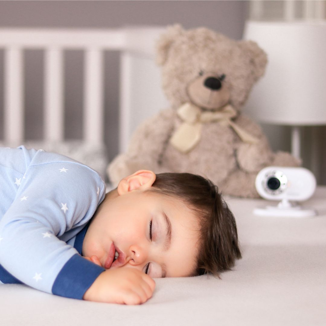 boy sleeping in bed with camera nearby