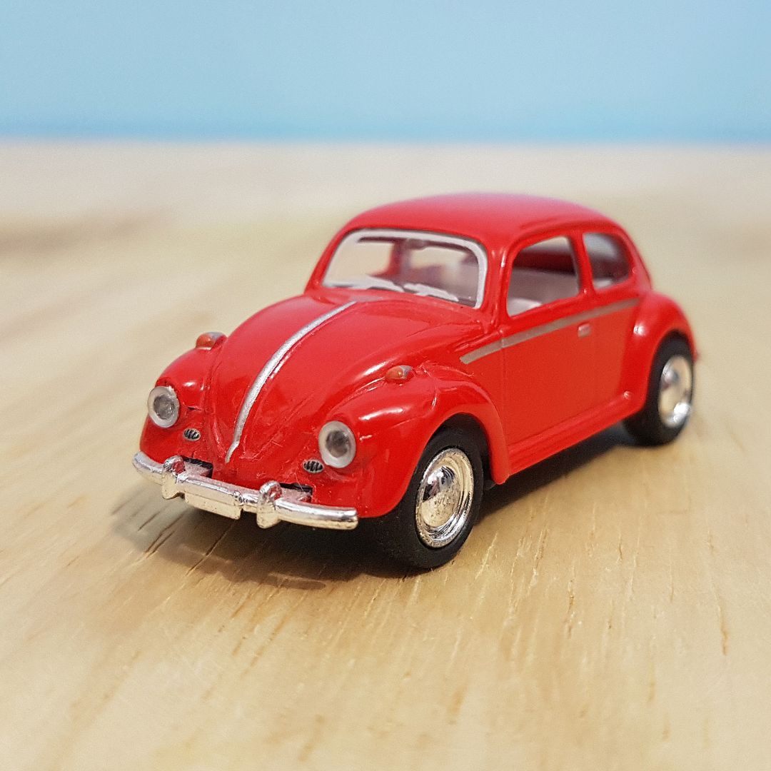 red VW beetle model on wood desk