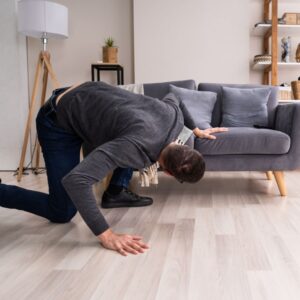man looking under couch