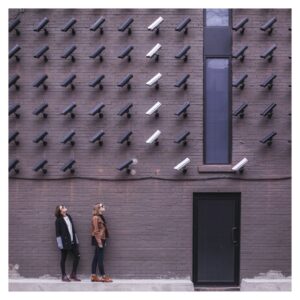 a wall of security cameras looking at two people