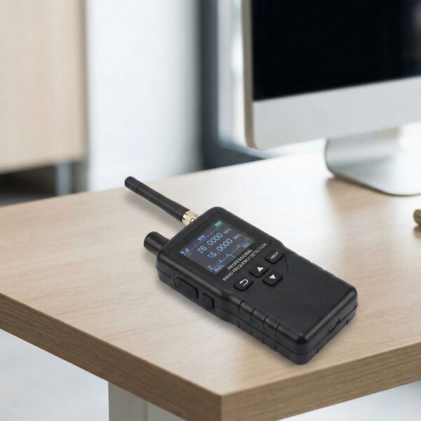 Close-up photograph of a professional handheld radio frequency detection device sitting on a clean desk surface.